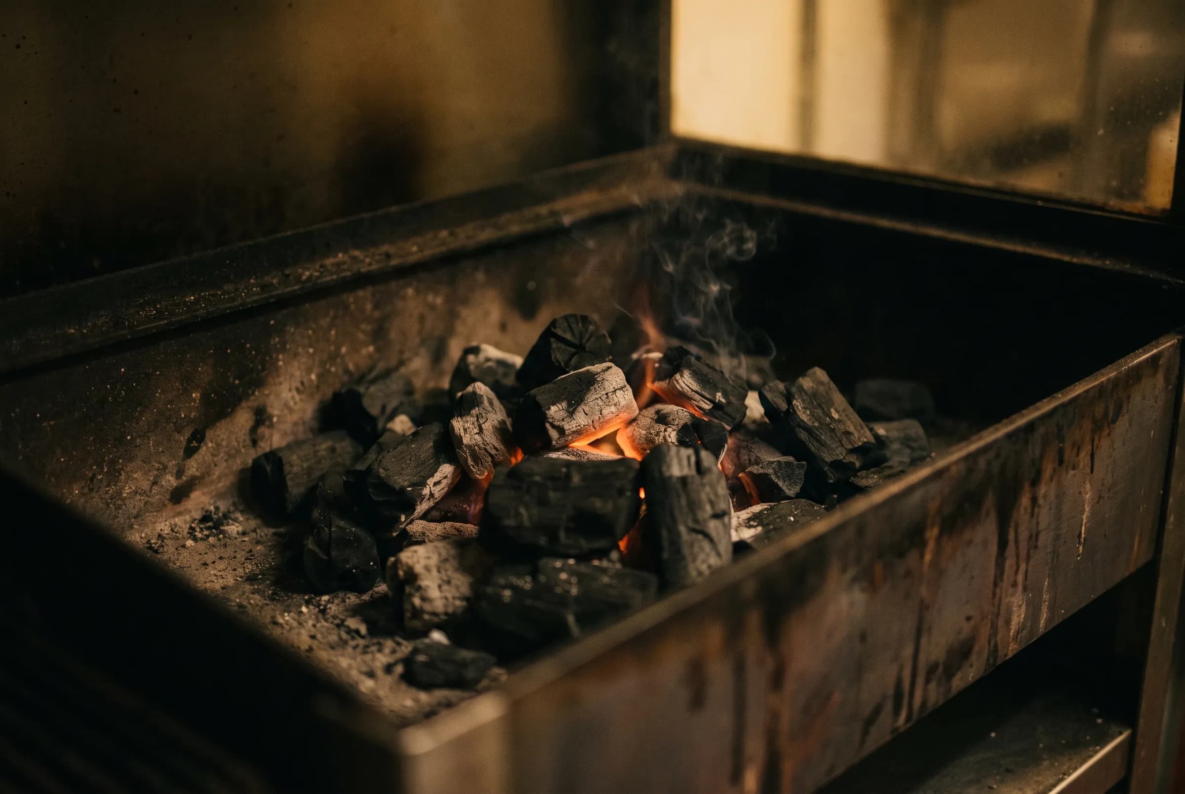 Glowing charcoal in a restaurant grill box